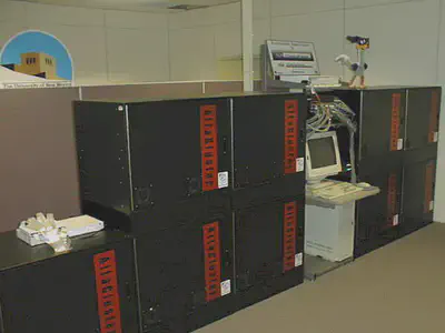 Linux prototype on lower-left, and Roadrunner (right). A Myricom dual 8-port SAN Myrinet switch sits on top of the left-most cabinet of the prototype, and four octal 8-port SAN Myrinet switches (not visible) connect Roadrunner. Above Roadrunner’s console is a 72-port Foundry Fast Ethernet switch with Gigabit uplinks to the vBNS and Internet. (Image credit: Courtesy of the author.)