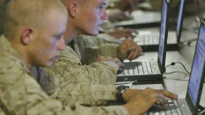 Iraq, Fallujah: US marines from the First Battalion, 5th Marines, Bravo Company, browse the internet at camp Mercury 25 April 2004. (AFP Photo / Nicolas Asfouri) © AFP