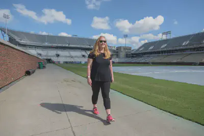 Julie Hawkins walks down the sideline of Grant Field back to the Wardlaw Center. Photo by Christopher Moore