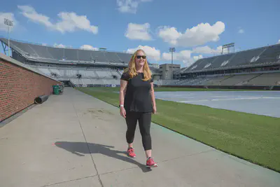 Julie Hawkins walks down the sideline of Grant Field back to the Wardlaw Center. Photo by Christopher Moore