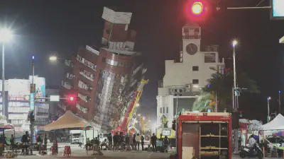 Emergency personnel stand in front of a partially collapsed building leaning over a street in Hualien on April 3, 2024, after a major earthquake hit Taiwan's east coast. Sam Yeh/AFP/Getty Images